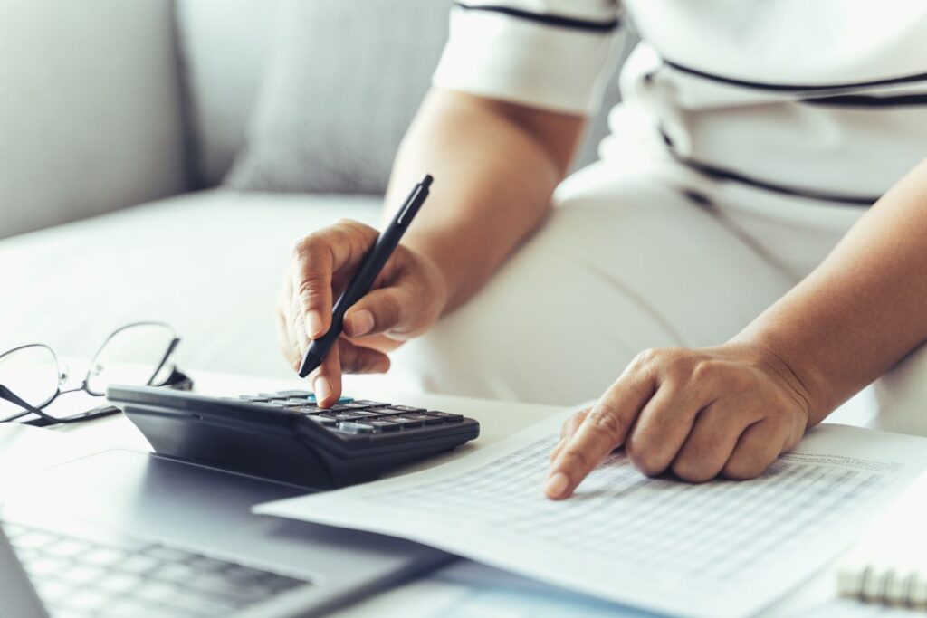 woman-is-calculating-annual-tax-with-calculator-and-filling