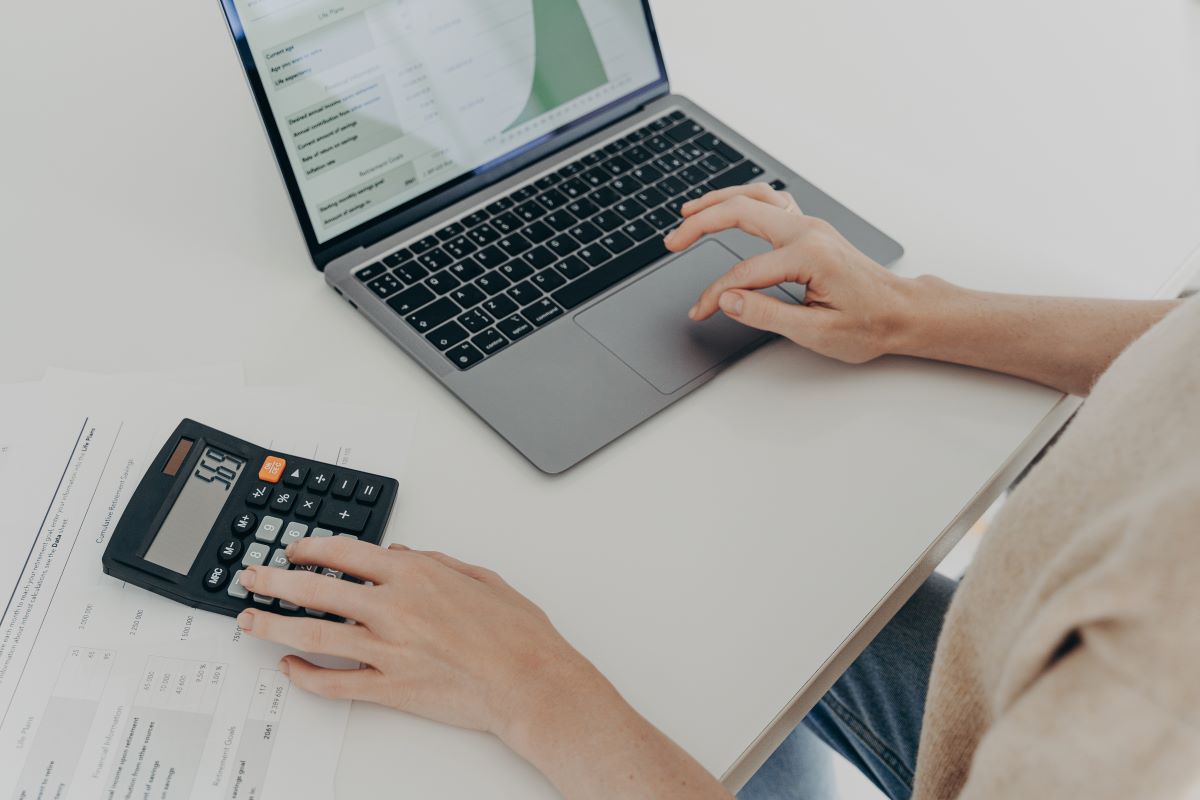 unrecognizable-woman-sits-at-desk-with-laptop-computer