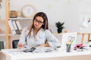 beautiful-woman-sitting-office-holding-magnifying-glass